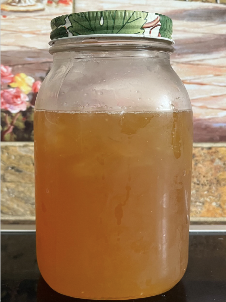 Large jar of golden liquid which is a honey digestive aid